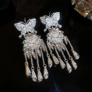 Detail of silver hollow butterfly and flower drop earrings with long metal tassels