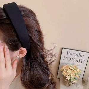 Close-up of elegant wide black fabric headband on model with French style background