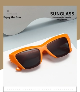 Detail of bright orange thick frame sunglasses with dark grey polarized lenses and sleek hinges