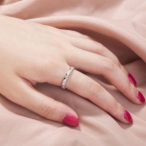 Close-up of a silver ring with heart-shaped cubic zirconia on a hand with red nails
