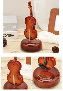 Detail of vintage violin music box with rotating base and polished wood grain finish