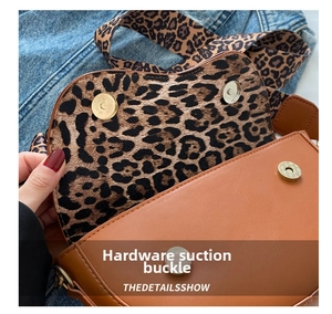 Close-up of magnetic snap closure and trendy leopard print lining on a brown saddle bag
