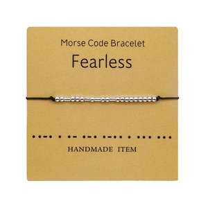 Detail of handmade Morse Code bracelet with Fearless message on display card