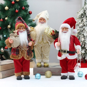 Three 18-inch standing Santa Claus figurines in red and gold outfits by a Christmas tree