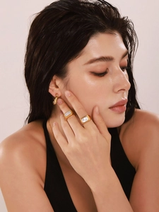 Dettaglio dell'anello placcato oro 18k con intarsio in conchiglia e orecchini a cerchio