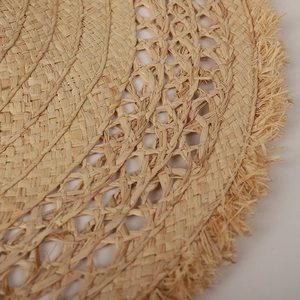 Handcrafted raffia straw sun hat with an oversized frayed brim and woven texture