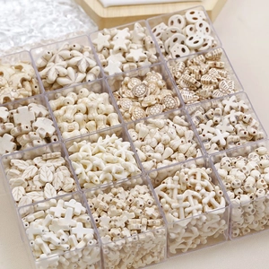 Detailed view of white turquoise beads in various shapes like stars and skulls in a storage box