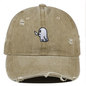 Close-up of ghost embroidery and distressed ripped details on a khaki baseball cap