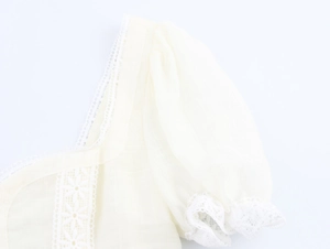 Close-up of the elegant square neckline and lace patchwork on puff sleeves blouse