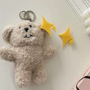 Porte-clés ours en peluche crème avec crochet doré sur un fond minimaliste élégant