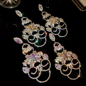 Vue macro de boucles d'oreilles à pompons ornées de strass et de pierres en goutte
