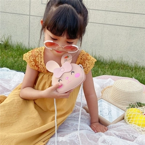 Mini borsa a tracolla rosa a forma di coniglio con fiocco per bambini in un parco soleggiato