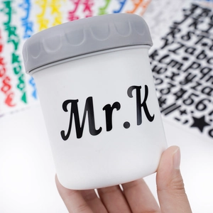 Détail macro des autocollants de lettres Mr.K sur un bocal de rangement en plastique blanc