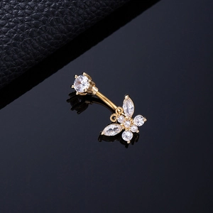 Macro shot of golden butterfly belly ring with sparkling white cubic zirconia