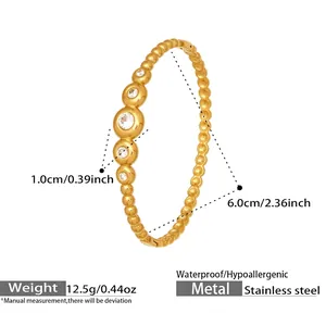 Detail of 18K gold stainless steel bangle with graduated round zircon inlay and dotted texture