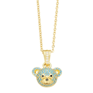 Detail of a gold bear pendant with inlaid blue turquoise-colored stones and clear zircon crystals