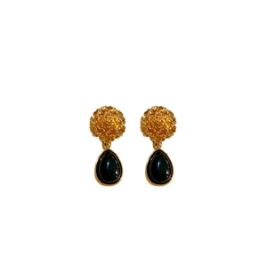 Vintage gold flower earrings with black pear-shaped pendants on white background