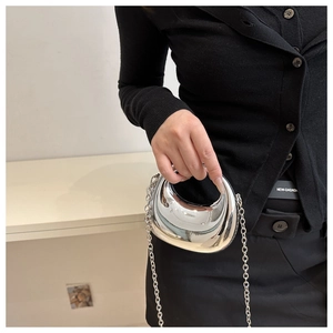 Petit sac argenté métallisé avec bandoulière chaîne porté par un mannequin en détail
