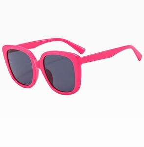 Close-up of trendy oversized square sunglasses in bright rose pink with dark grey lenses