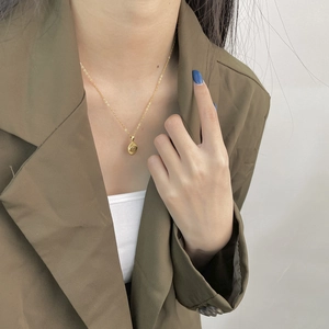 Close-up of a 925 sterling silver evil eye pendant necklace worn by a fashion model