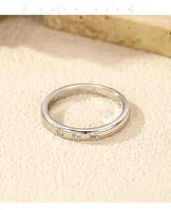 Vue macro d'une bague en argent 925 avec trois zircons ronds sur un support en pierre