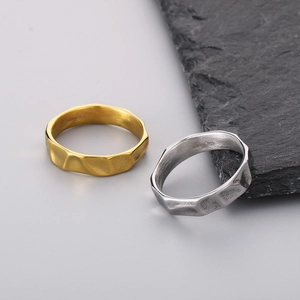 Detailed view of irregular hammered texture on gold and silver stainless steel rings