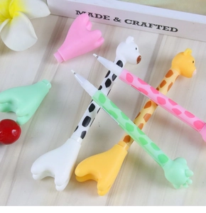 Close-up of cute cartoon giraffe pens with soft silicone heads on a wooden background