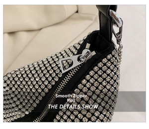 Detailed close-up of a silver rhinestone handbag featuring a smooth triangular metal zipper