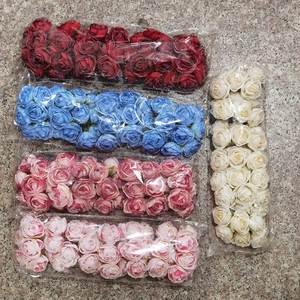 Detailed view of assorted artificial rose heads in red, blue, pink and white packaging