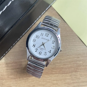 Detailed top view of a quartz watch with a white dial and silver elastic steel band