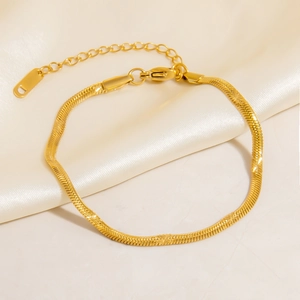 Close-up of golden snake chain bracelet with lobster clasp on elegant silk background