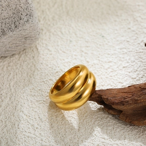Detailed close-up of a 18K gold-plated heart ring on an elegant minimalist stone display