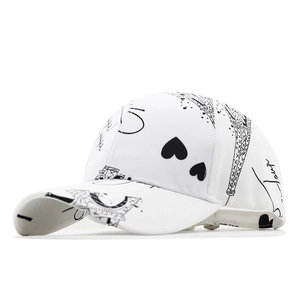 White baseball cap with black Eiffel Tower and heart print shown from a side angle