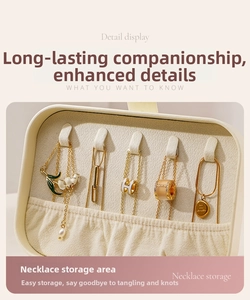 Detail view of cream jewelry box with five necklace hooks and elastic storage pocket