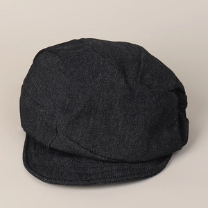 Close-up of the pleated black denim fabric and stitching on a retro newsboy cap