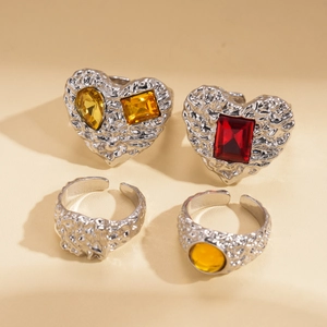 Detail of four vintage silver resin rings with colorful gemstones and textured finish