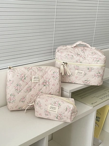 Dettaglio di un set di tre pochette per trucchi trapuntate con motivi di rose rosa