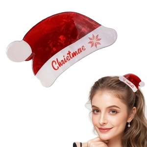 Detail view of a cute red Christmas hat hair claw clip with white festive lettering