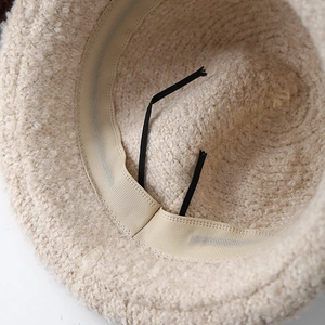 Detail of plush winter hat interior showing beige sweatband and adjustable drawstring