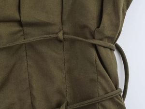Gros plan détaillé du cordon à la taille et des coutures de la robe midi vert armée