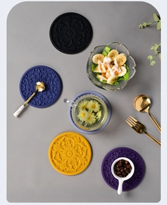 Detailed top view of five colorful silicone heat-resistant mats with intricate floral patterns