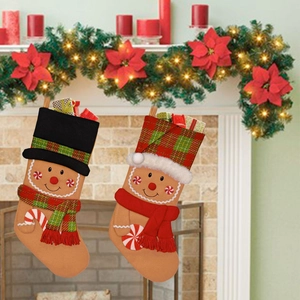 Detail of two gingerbread man Christmas stockings hanging on a festive decorated fireplace