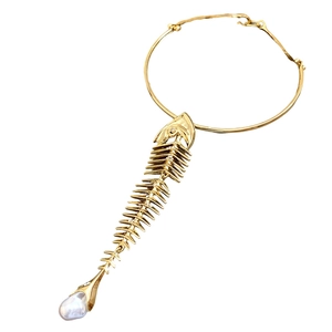 Gold fishbone pendant necklace with pearl and rhinestones on a white background