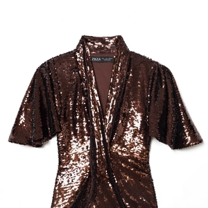 Abito corto alla moda con paillettes color bronzo e dettagli scintillanti su bianco