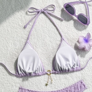 Detailed texture of lavender smocked bikini with starfish charm and pearl accents