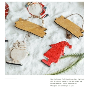 Detail of resin snowman and Santa Claus ornaments on a wooden plaque in snowy scenery