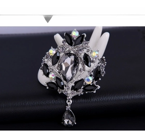 Detailed macro of vintage silver brooch with grey drop stone and iridescent rhinestones