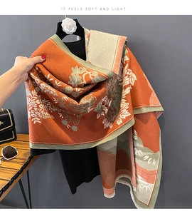 Detail view of the soft cashmere-like fabric texture with elegant orange floral patterns