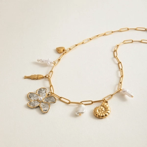 Détail du collier chaîne trombone doré avec perles et pendentifs fleur et coquillage