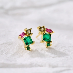 Detailaufnahme der 18K vergoldeten Ohrstecker mit grünen und rosa Zirkon-Steinen
